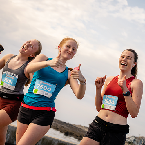 girls running giving thumbs up
